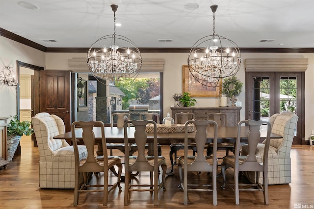 dining room featuring hardwood / wood-style flooring, ornamental molding, and an inviting chandelier