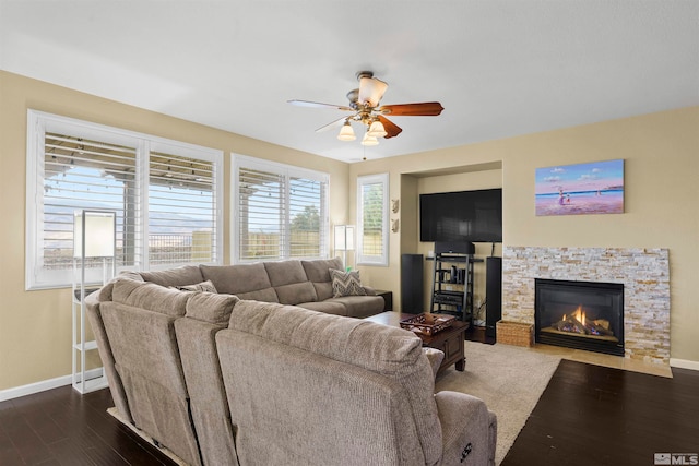 living room featuring ceiling fan, dark hardwood / wood-style flooring, and a fireplace