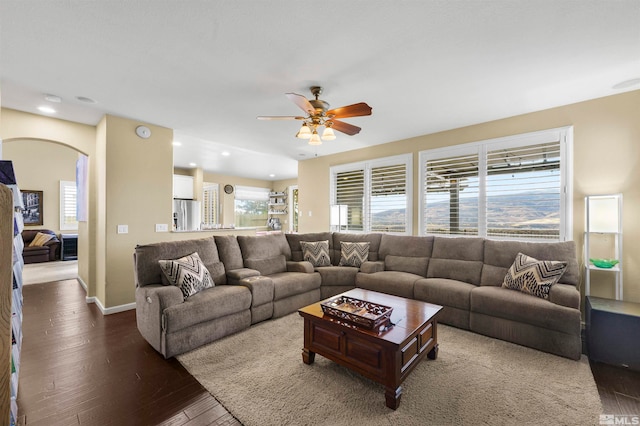 living room featuring ceiling fan and dark hardwood / wood-style flooring