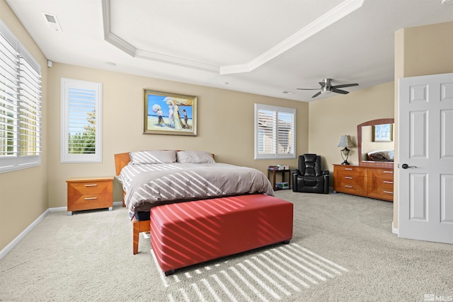 bedroom with ceiling fan, ornamental molding, a tray ceiling, and carpet floors