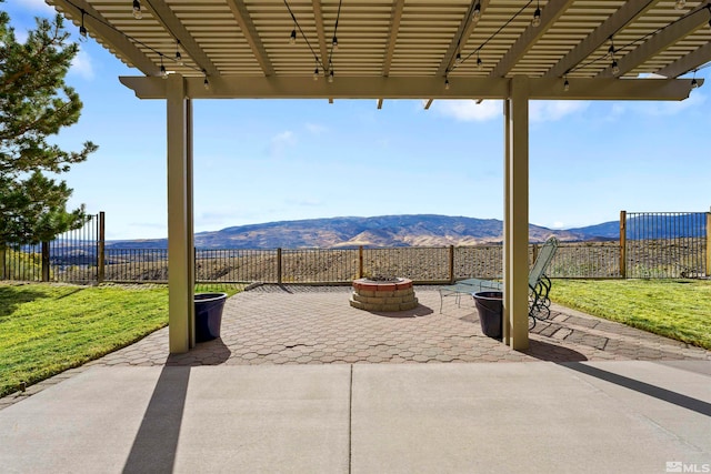 view of patio featuring a pergola, a mountain view, and a fire pit