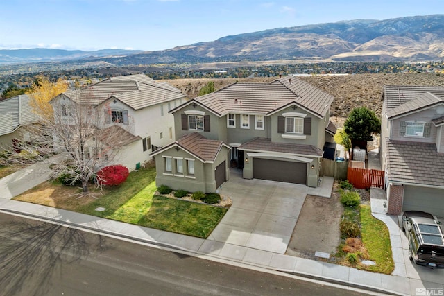 view of front of property with a mountain view, a front yard, and a garage