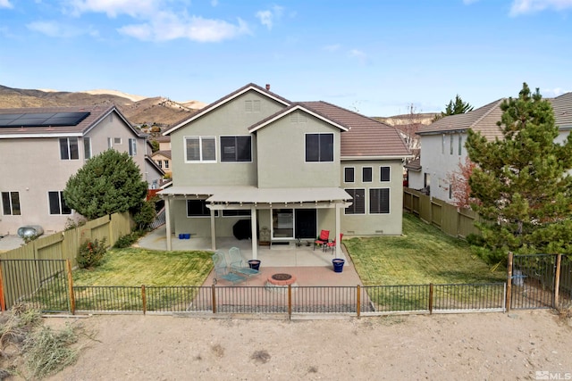 back of property with a patio, a mountain view, and a yard