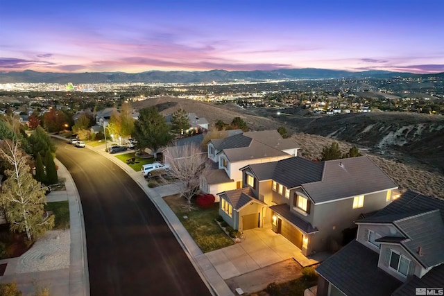 aerial view at dusk featuring a mountain view