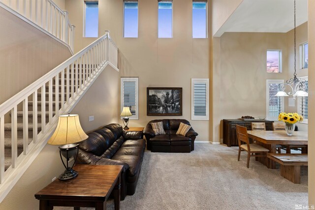 living room featuring carpet floors, a healthy amount of sunlight, and a high ceiling