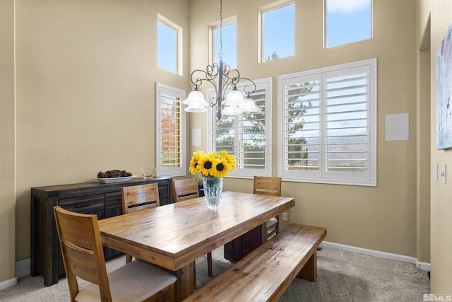 dining room featuring a healthy amount of sunlight, carpet flooring, and a chandelier