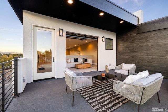 patio terrace at dusk with an outdoor living space with a fire pit