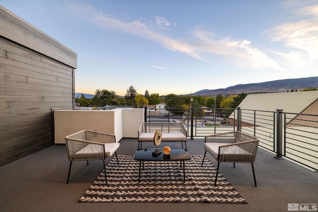 patio terrace at dusk featuring a mountain view and a balcony