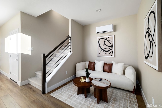 living room featuring light hardwood / wood-style flooring and a wall unit AC