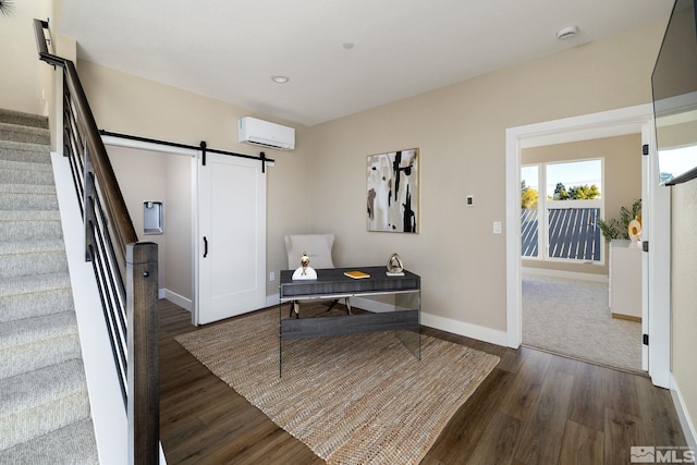 home office with a wall unit AC, a barn door, and dark hardwood / wood-style flooring