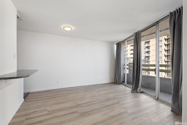 interior space featuring expansive windows and light hardwood / wood-style floors