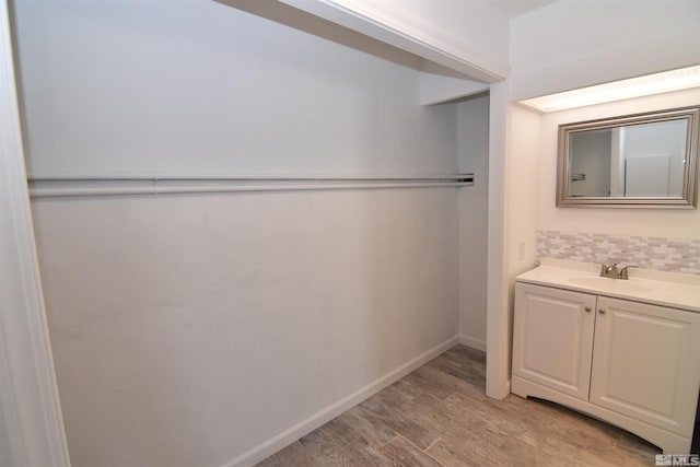 bathroom featuring decorative backsplash, hardwood / wood-style floors, and vanity