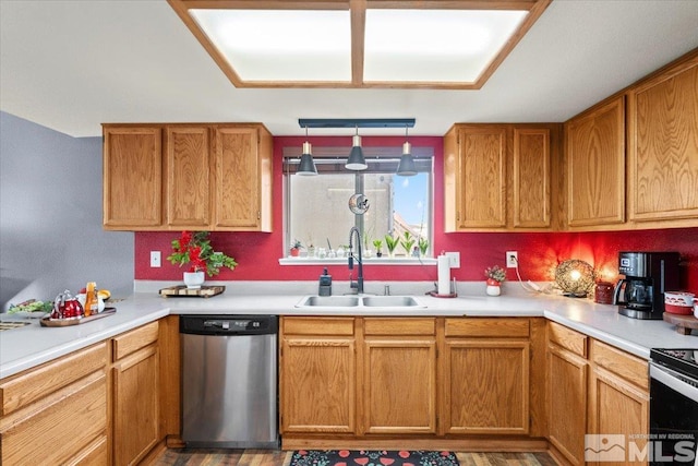 kitchen featuring stainless steel appliances, sink, hardwood / wood-style floors, and hanging light fixtures