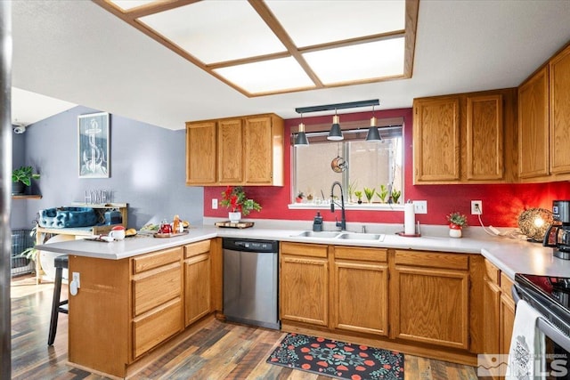 kitchen featuring kitchen peninsula, stainless steel dishwasher, dark hardwood / wood-style floors, decorative light fixtures, and sink