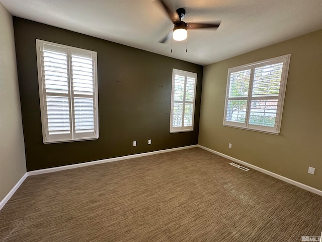 empty room with dark carpet and ceiling fan