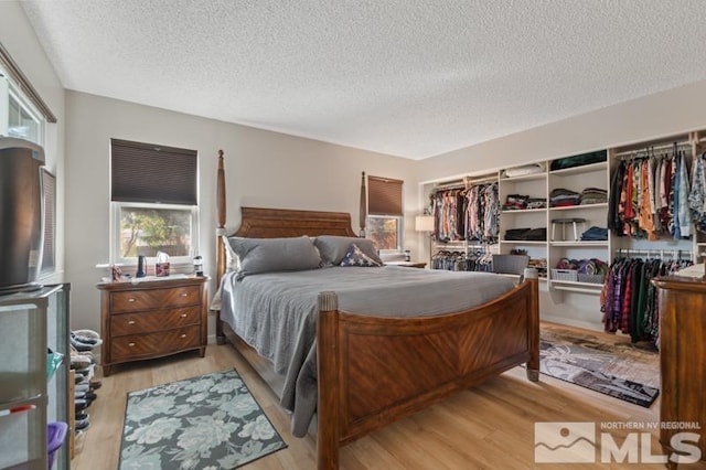 bedroom with light hardwood / wood-style flooring and a textured ceiling