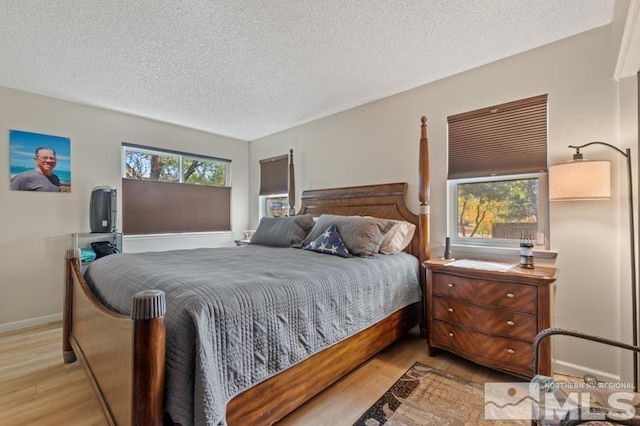 bedroom featuring a textured ceiling and light wood-type flooring