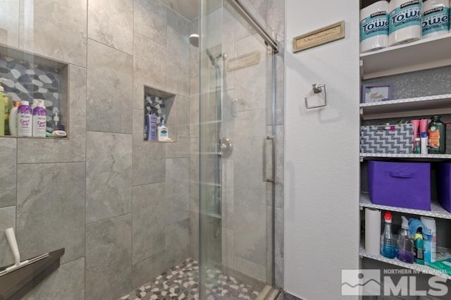 bathroom featuring a shower with shower door