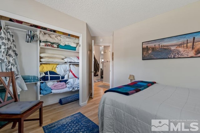 bedroom with a textured ceiling and light hardwood / wood-style floors