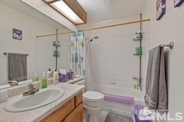 full bathroom featuring a skylight, toilet, tile patterned floors, shower / bath combo with shower curtain, and vanity