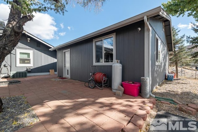 rear view of property with central air condition unit and a patio area