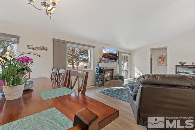 dining area featuring light hardwood / wood-style floors, lofted ceiling, and a chandelier