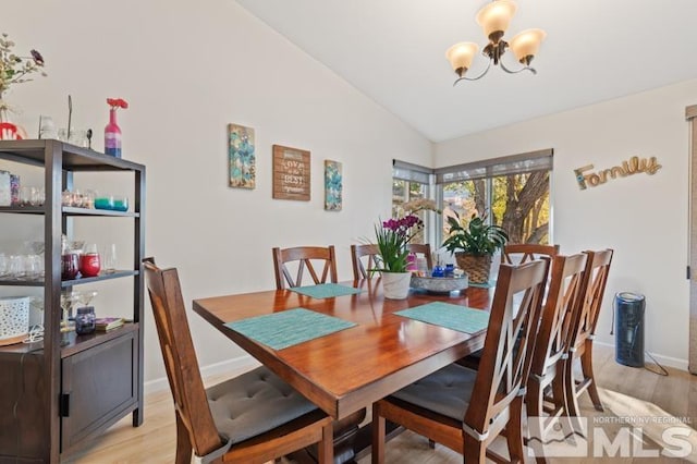 dining room featuring lofted ceiling, a chandelier, and light wood-type flooring