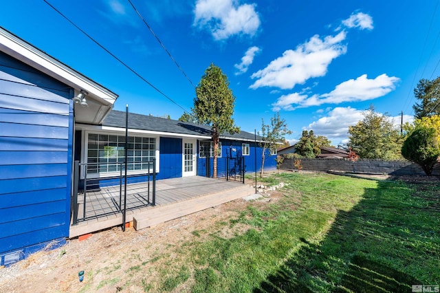 exterior space featuring a wooden deck and a lawn