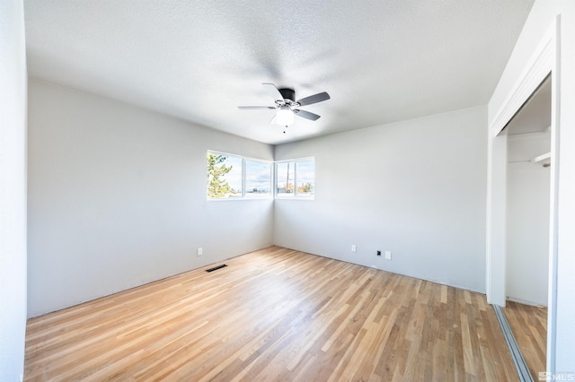 unfurnished bedroom with a closet, ceiling fan, a textured ceiling, and light wood-type flooring