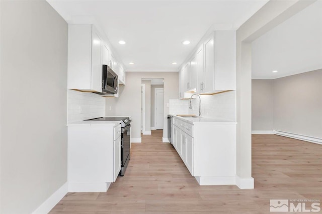 kitchen featuring sink, appliances with stainless steel finishes, white cabinetry, and light wood-type flooring