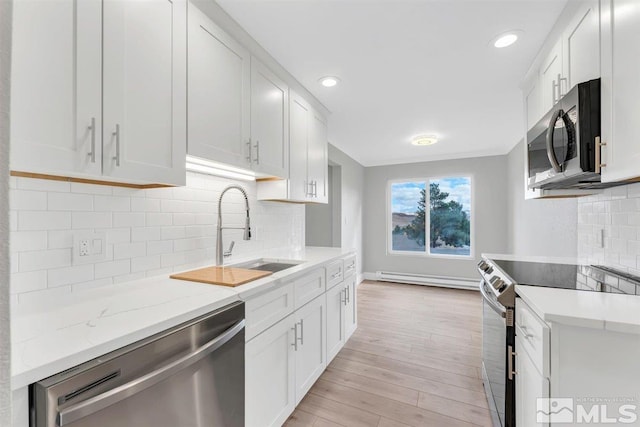 kitchen featuring white cabinetry, appliances with stainless steel finishes, sink, and light wood-type flooring