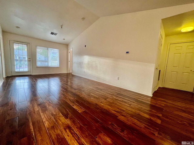 empty room with lofted ceiling and dark wood-type flooring