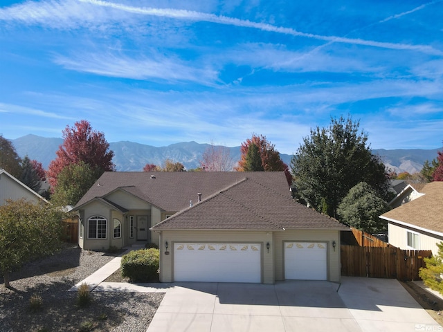 ranch-style house with a garage and a mountain view