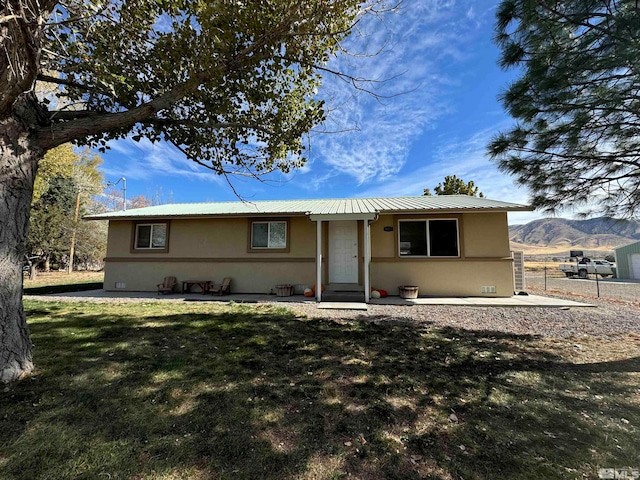 ranch-style home featuring a mountain view and a front lawn