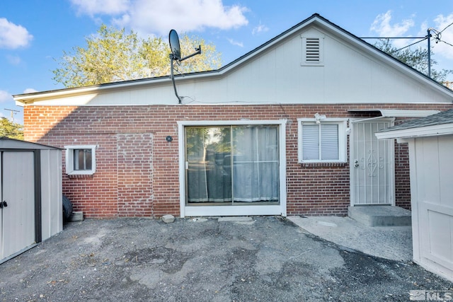 back of house featuring a storage shed and a patio area