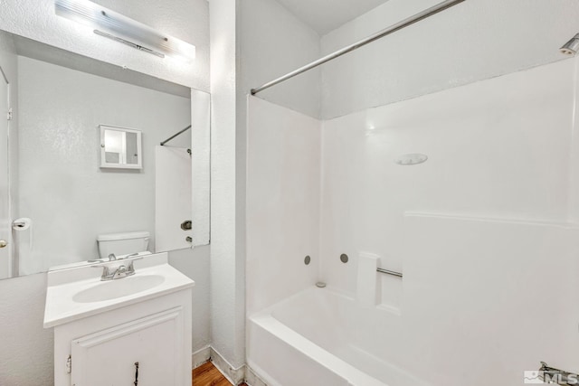 full bathroom with toilet, hardwood / wood-style flooring, vanity, and bathing tub / shower combination