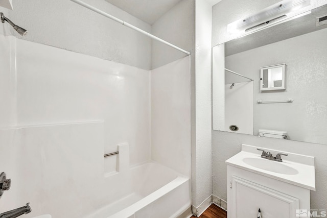 full bathroom with vanity, bathing tub / shower combination, toilet, and hardwood / wood-style flooring