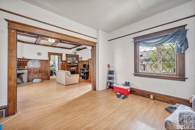 living room with a brick fireplace and hardwood / wood-style floors