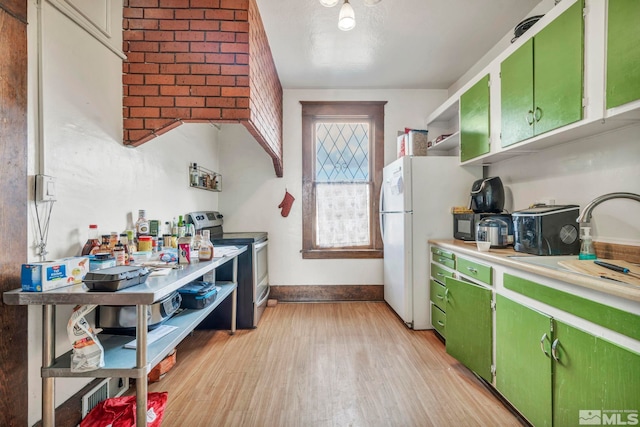 kitchen featuring white fridge, stainless steel electric range, green cabinets, and light wood-type flooring