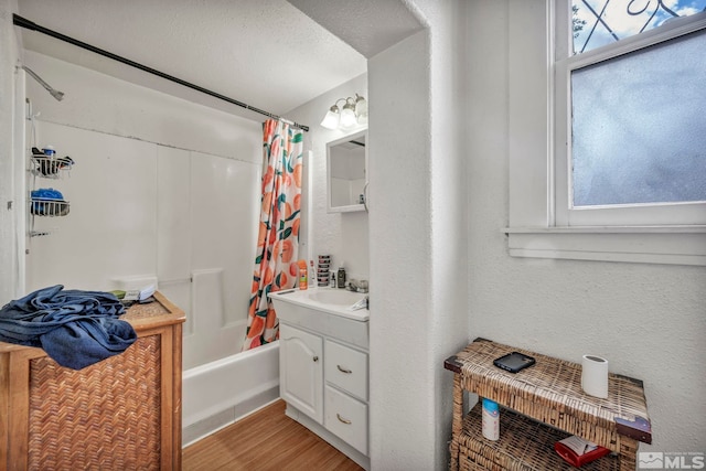 bathroom with vanity, hardwood / wood-style floors, a textured ceiling, and shower / bathtub combination with curtain