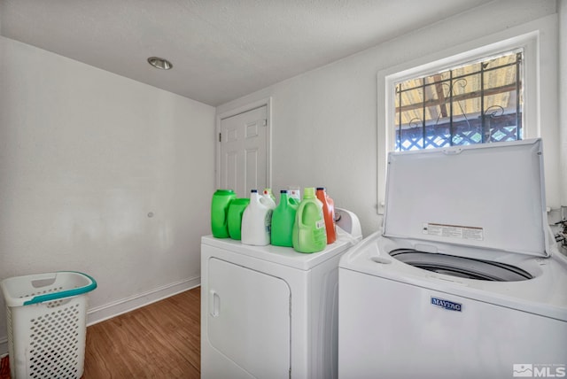 washroom featuring a textured ceiling, washer and dryer, and wood-type flooring