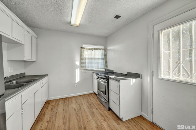 kitchen featuring light hardwood / wood-style floors, white cabinetry, stainless steel range with electric cooktop, and a textured ceiling