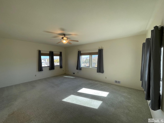 carpeted spare room with ceiling fan