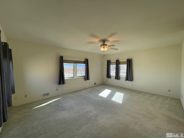 unfurnished room featuring light colored carpet and ceiling fan