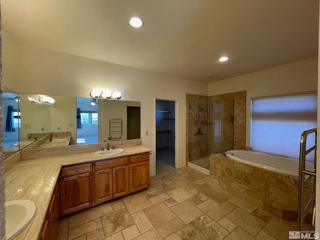 bathroom with vanity, plus walk in shower, and a textured ceiling