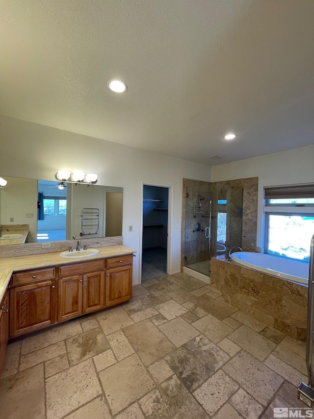 bathroom with vanity and shower with separate bathtub