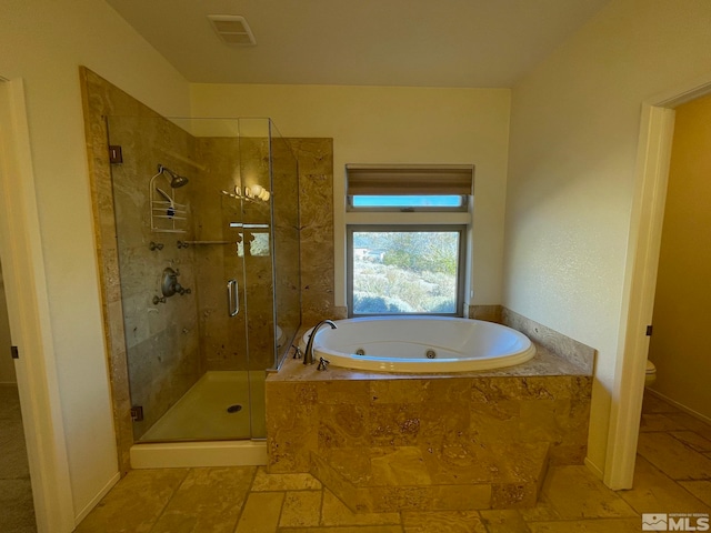 bathroom featuring toilet and independent shower and bath