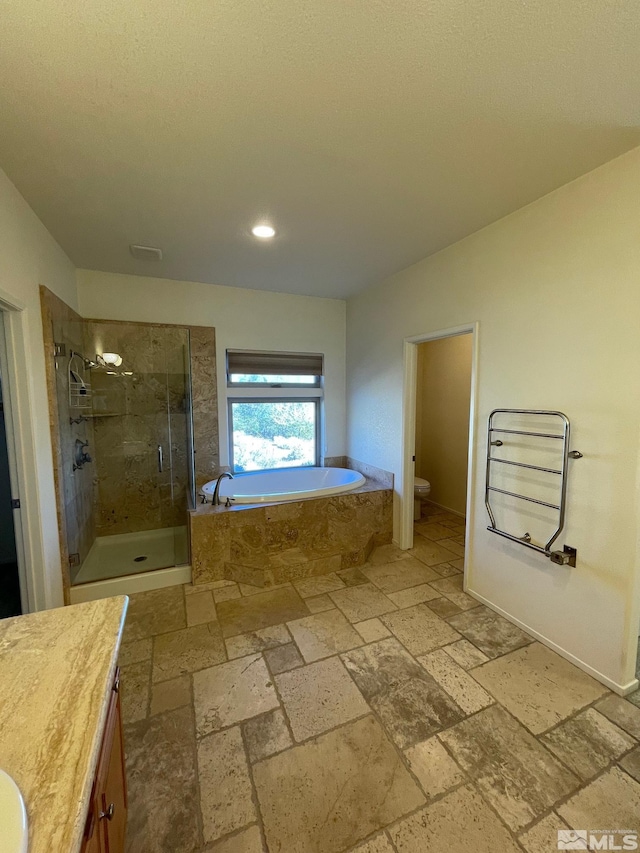 full bathroom featuring toilet, plus walk in shower, and vanity