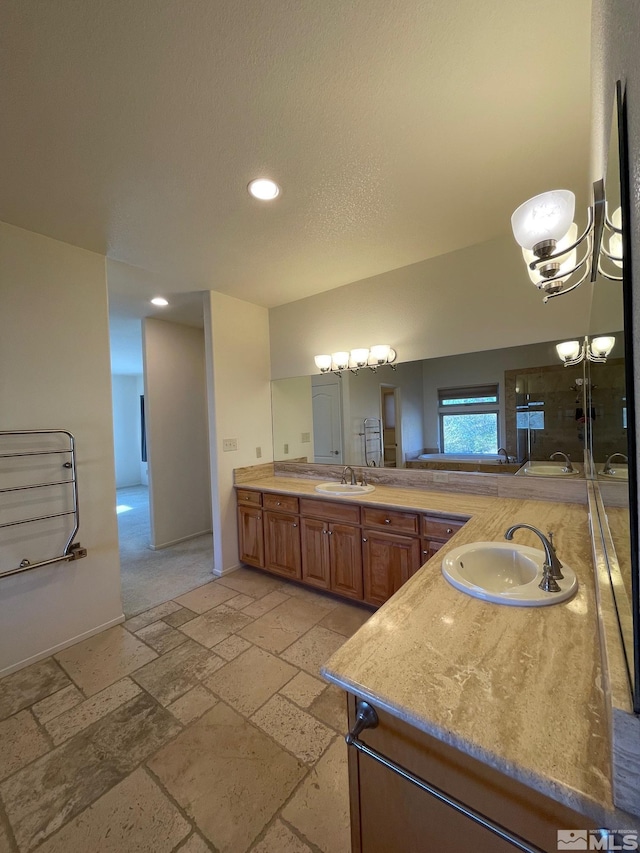 bathroom featuring vanity, an inviting chandelier, and a textured ceiling