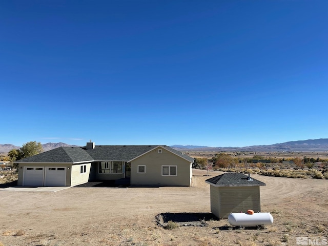 view of front of property featuring a garage and a mountain view